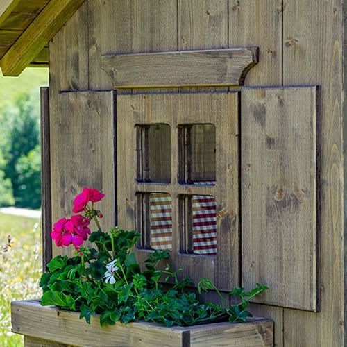 Alpenlaube mit Blumenkasten und Fensterladen in Grundfarbe